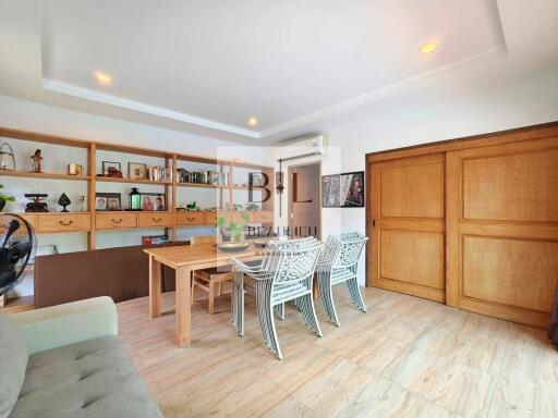 Spacious main living area with wooden shelves, table, and chairs