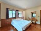 Spacious bedroom with wooden furniture and large window