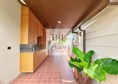 Narrow kitchen with wooden cabinets and plants