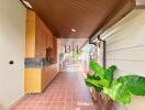 Narrow kitchen with wooden cabinets and plants