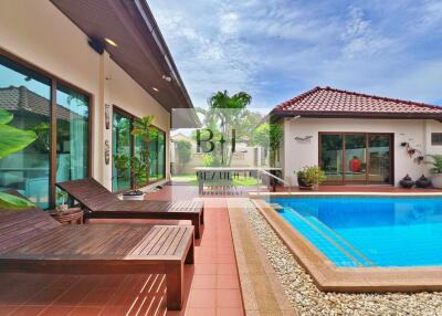 Outdoor pool area with lounge chairs and a view of the garden