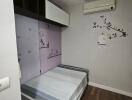 Small bedroom with wall art and air conditioner