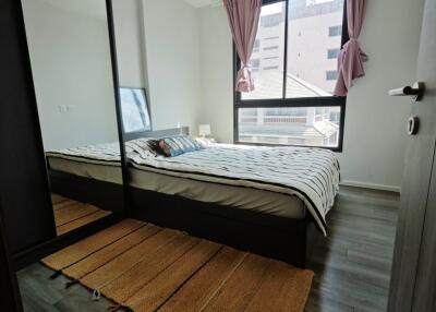 Modern bedroom with large window and striped bedding