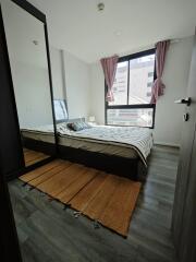 Modern bedroom with large window and striped bedding