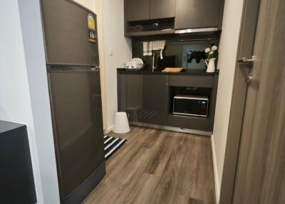 Modern kitchen with dark cabinetry and wood flooring