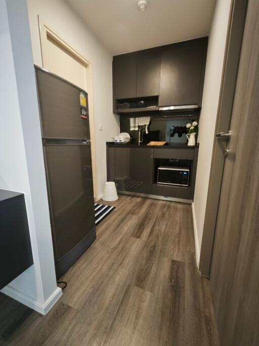 Modern kitchen with dark cabinetry and wood flooring