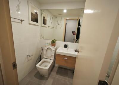 Modern bathroom with mirror, toilet, sink, and wall decorations