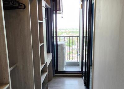 Walk-in closet with shelving and hanging space leading to a balcony.