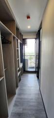 Walk-in closet with shelving and hanging space leading to a balcony.