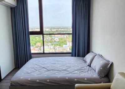 Bedroom with large window and city view