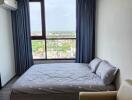 Bedroom with large window and city view