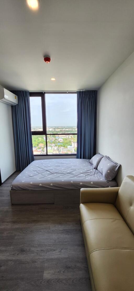 Bedroom with large window and city view