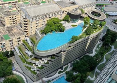 Aerial view of modern buildings with rooftop pool and greenery