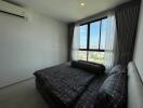 Modern bedroom with large window and city view