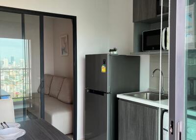 Modern kitchen and dining area with a view of another room