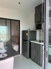 Modern kitchen and dining area with a view of another room