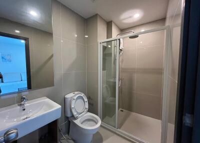 Modern bathroom with glass shower enclosure, sink, and toilet