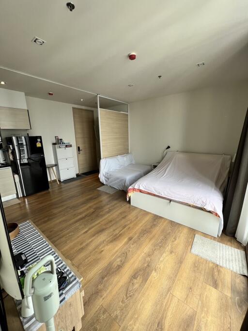 Modern bedroom with wooden flooring and white walls.