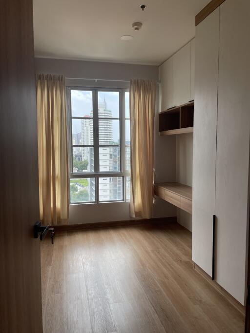 Bright bedroom with wooden flooring and large window