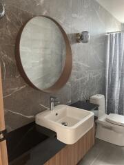 Modern bathroom with round mirror and vessel sink