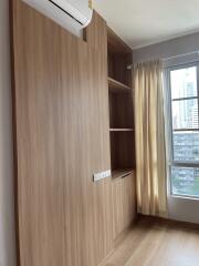 Bedroom with wooden storage unit and window view