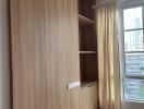 Bedroom with wooden storage unit and window view