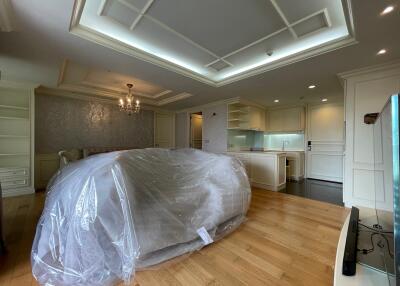 Living room with covered furniture, hardwood flooring, and ceiling lights