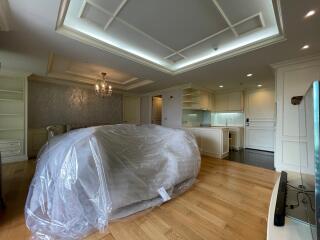 Living room with covered furniture, hardwood flooring, and ceiling lights