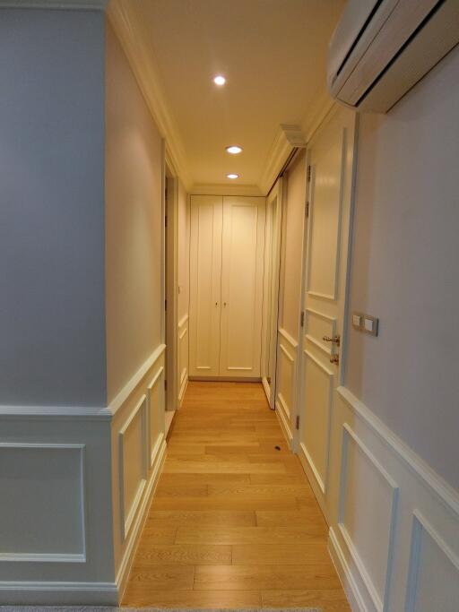 Bright hallway with wooden flooring and decorative wall panels