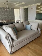 Spacious living room with a chandelier and a large sofa