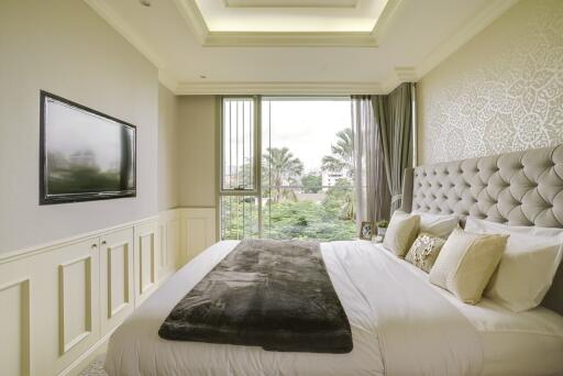 Bright and cozy bedroom with large windows and a wall-mounted TV