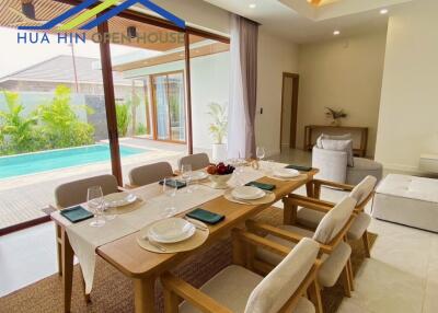 Modern dining area overlooking a pool with a large sliding glass door