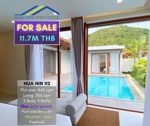 Living area with large window overlooking pool and mountain view