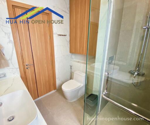 Modern bathroom with glass shower and wooden door