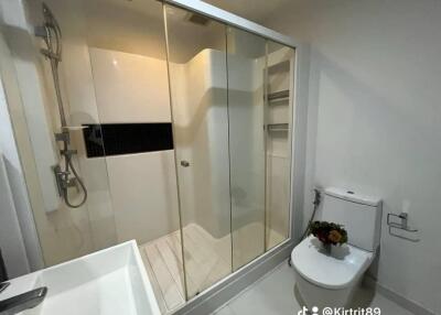 Modern bathroom with glass shower, sink, and toilet