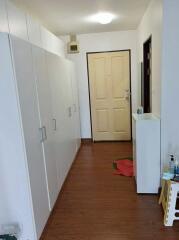 Hallway with wooden flooring and white cabinets