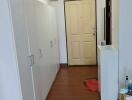 Hallway with wooden flooring and white cabinets