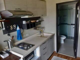 Small modern kitchen with appliances and a view of an adjacent bathroom