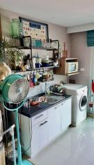 Small kitchen with various appliances and a fan