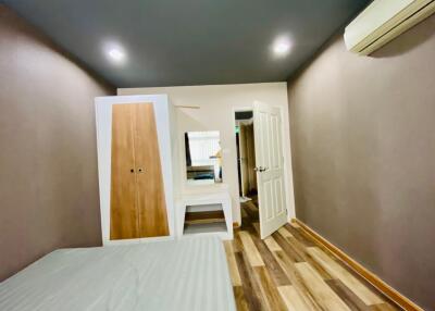 Bedroom with wooden furniture and air conditioning.