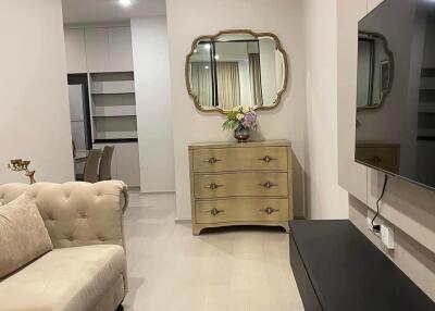 Modern living room with beige sofa, decorative mirror, and TV