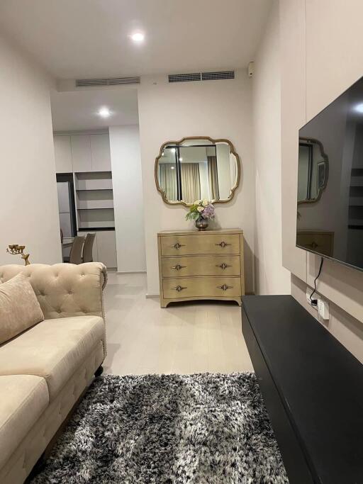 Modern living room with beige sofa, decorative mirror, and TV