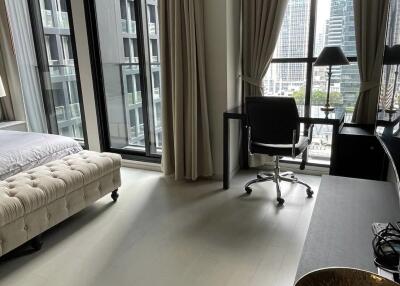 Modern bedroom with large windows offering a view of the cityscape