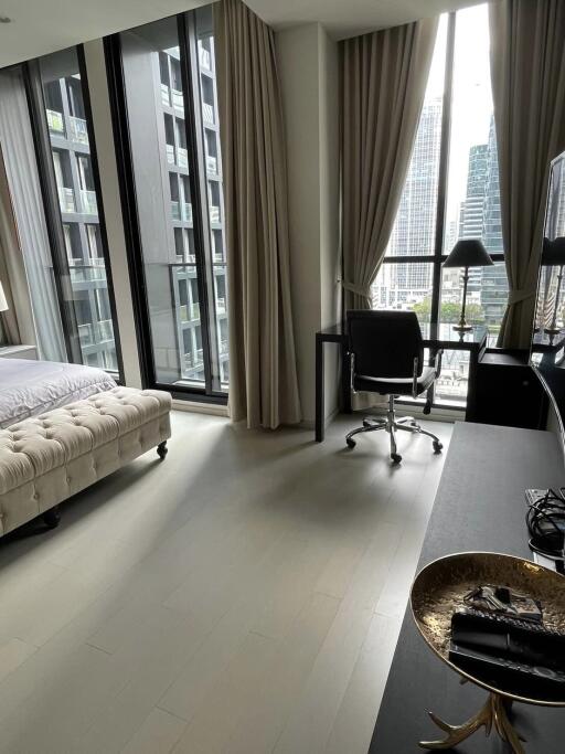 Modern bedroom with large windows offering a view of the cityscape