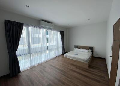 spacious bedroom with large window and curtains