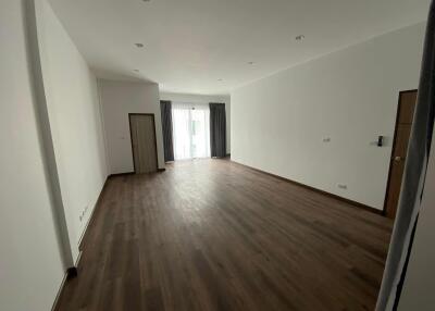 Spacious and empty living room with large windows and curtains