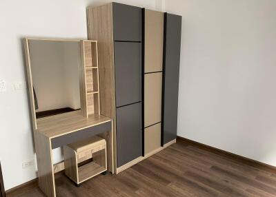 Bedroom with wooden floor, wardrobe, and vanity table