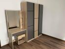 Bedroom with wooden floor, wardrobe, and vanity table