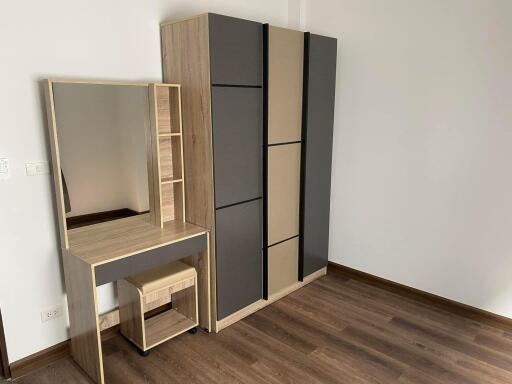 Bedroom with wooden floor, wardrobe, and vanity table