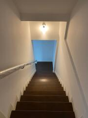 Well-lit staircase with wooden steps